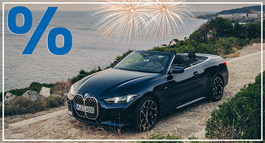 Ein dunkelblaues BMW Cabrio steht bei Dämmerung an einer Meeresküste. Über dem Wasser ist ein goldenes Feuerwerk zu sehen. Ein großes blaues Prozentzeichen in der Ecke signalisiert eine Rabattaktion zum Jahresstart.