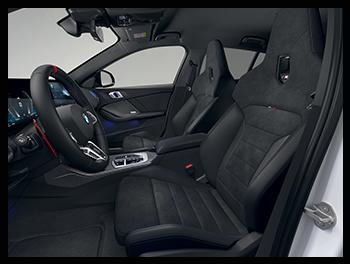 Das Cockpit des BMW M135 xDrive ist mit dem modernen BMW Curved Display und sportlichen Alcantara-Sitzen mit blauen Kontrastnähten ausgestattet.