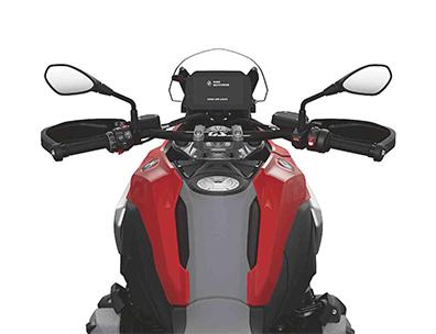  Auf dem Bild ist eine BMW R 1300 GS abgebildet, ein großes, rotes und schwarzes Motorrad, das auf einem weißen Hintergrund steht.  Das Bild zeigt eine Nahaufnahme der Front des Motorrads, von der Perspektive eines Fahrers. Man sieht den Lenker mit Spiegeln, das beleuchtete Armaturenbrett, das BMW-Logo und den Tank. Es ist sauber und glänzt, als wäre es brandneu.