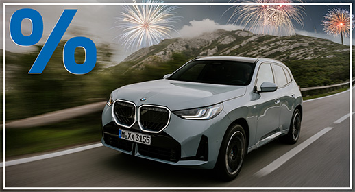 In dieser Grafik ist ein hellgrauer BMW X3 (Kennzeichen „M XX 3155“) zu sehen, der zügig über eine kurvige Bergstraße fährt. Die Szenerie wirkt durch den bewölkten Himmel und die grün bewachsenen Hänge etwas kühler, wird jedoch durch drei große, hell leuchtende Feuerwerksgarben über den Berggipfeln festlich aufgehellt. Auch hier signalisiert das markante blaue Prozentzeichen oben links ein besonderes Angebot, während das gesamte Motiv durch einen schmalen weißen Rahmen professionell eingefasst wird.